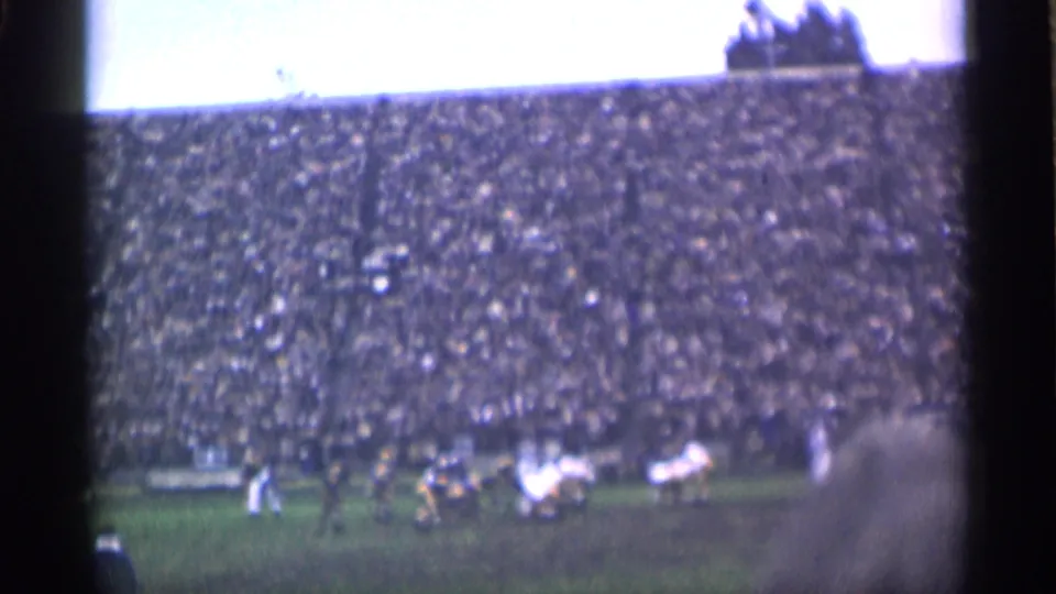 A distant 1944 San Francisco stadium view shows clustered players on the field with a large crowd in the stands.