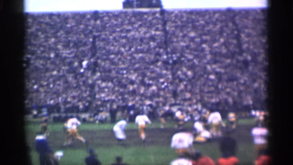San Francisco 1944 8mm frame showing football players spread across the field beneath a densely filled grandstand.