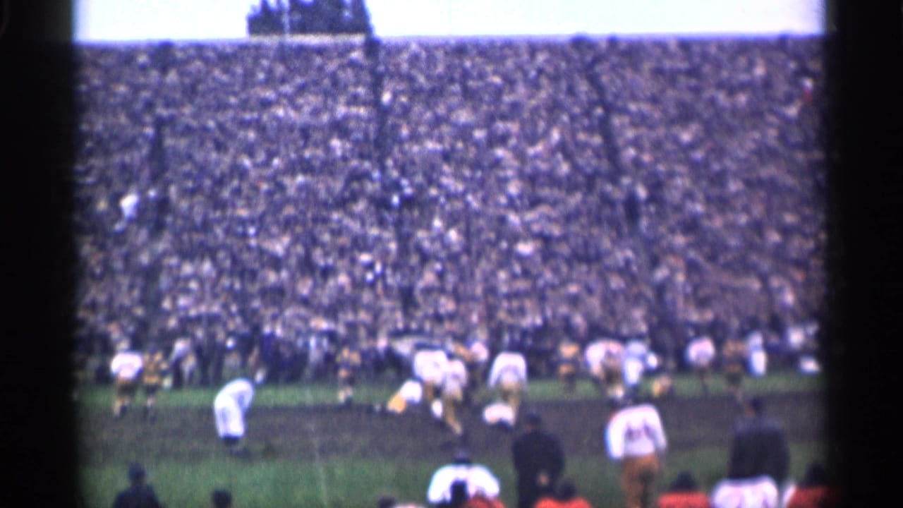 Wide 1944 San Francisco football scene with players in white and dark uniforms spread across the field before crowded stands.