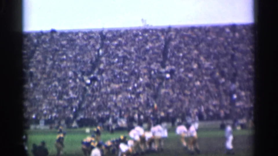 1944 San Francisco stadium football scene with players in white and dark uniforms spread across the field before a packed grandstand.