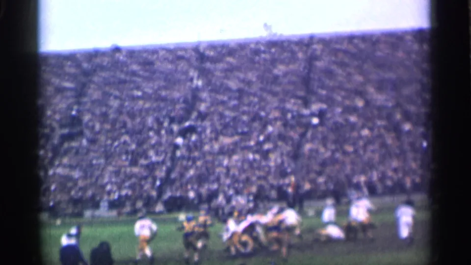 College football players converge around the advancing play in 1944 San Francisco home-movie footage.