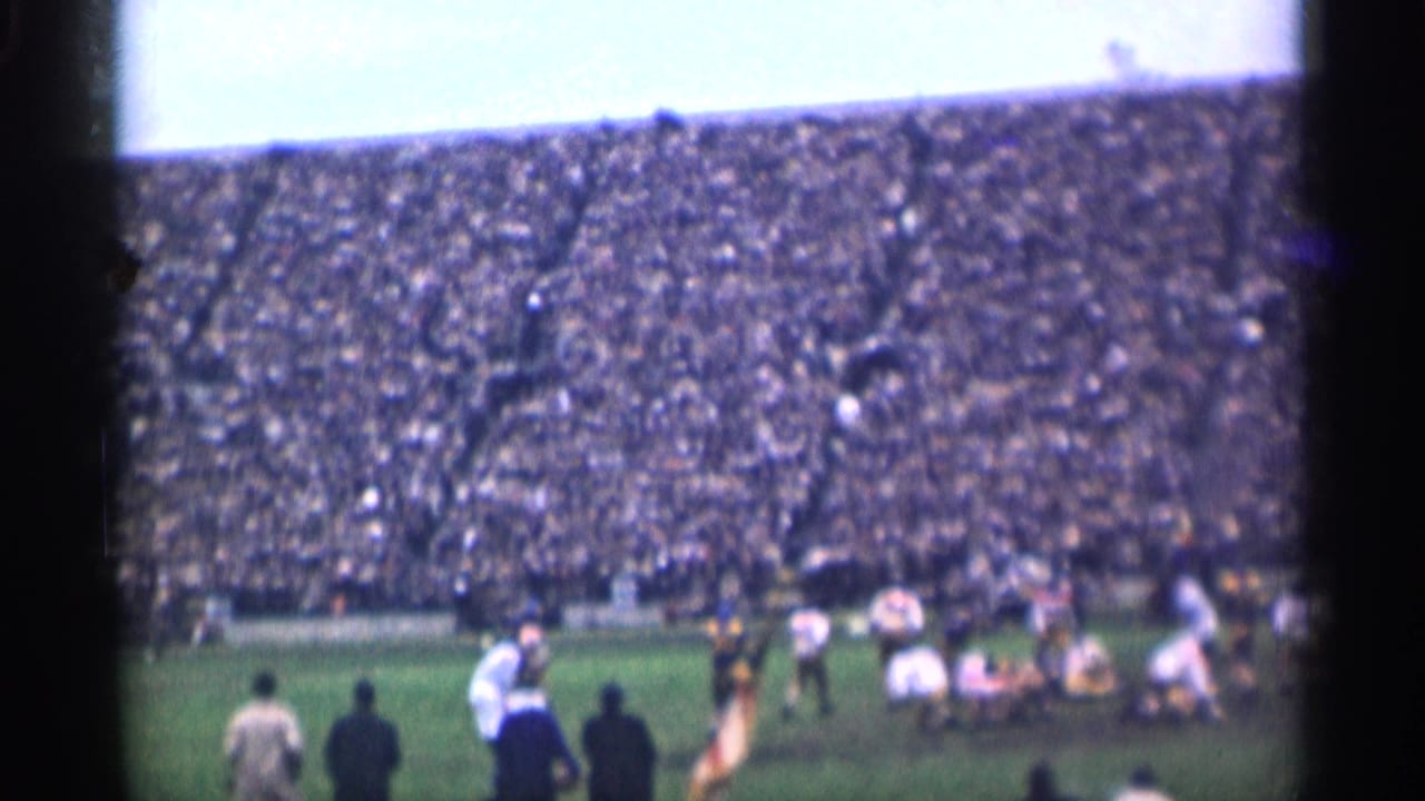 1944 San Francisco football footage shows players near the line of scrimmage with spectators filling the stands behind them.