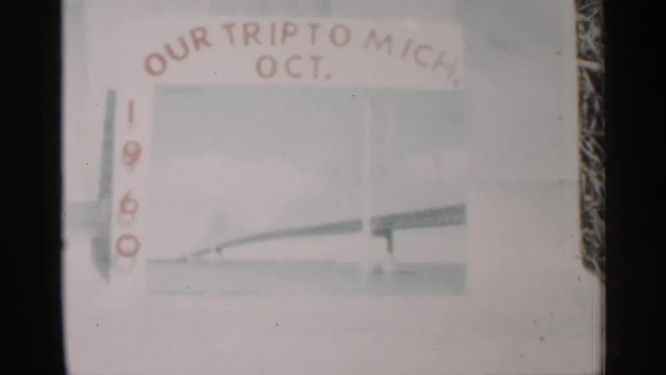 1960 home-movie title card for a Michigan trip, showing pale lettering and a faint travel drawing within the film frame.