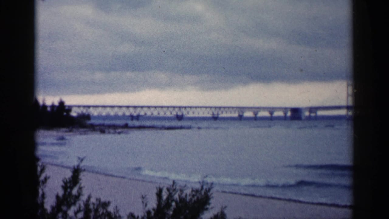 Bridge crossing a wide body of water beneath an overcast sky.