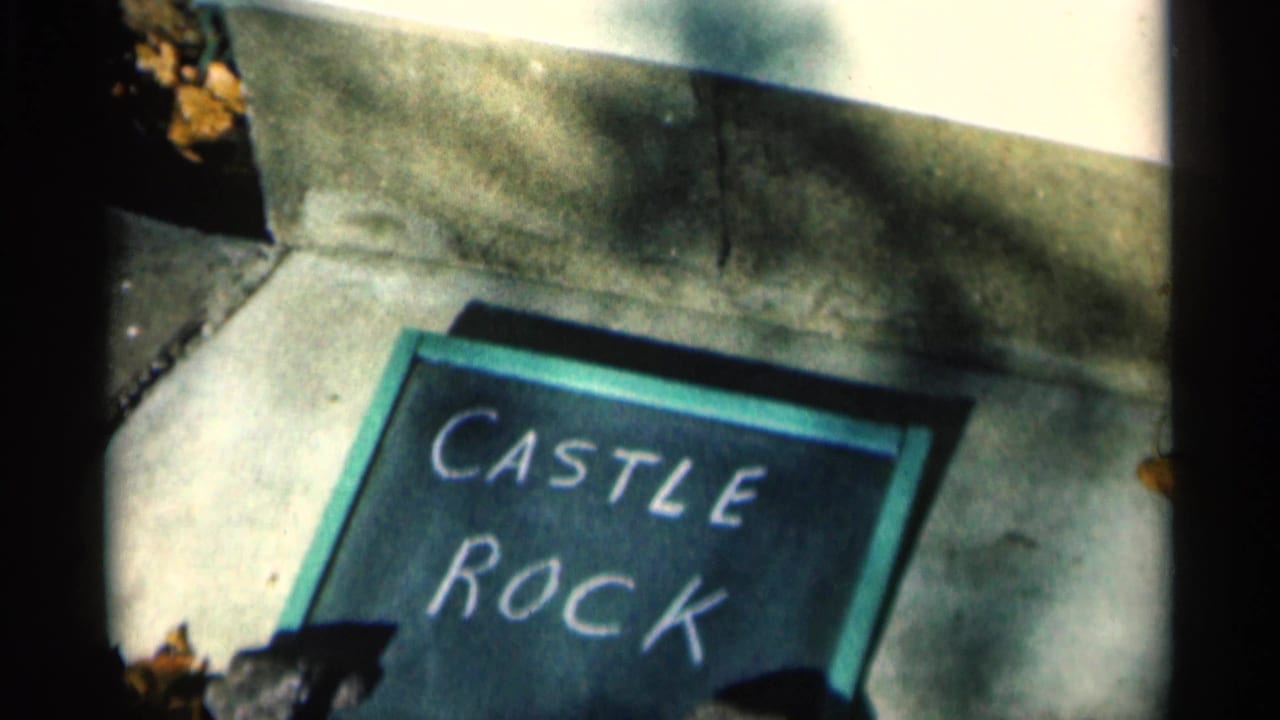 1960 Michigan 8mm frame showing a green-framed chalk sign reading Castle Rock on concrete with dark film edges.