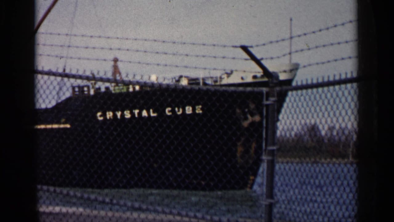 Black tanker Crystal Cube behind a chain-link fence topped with barbed wire.