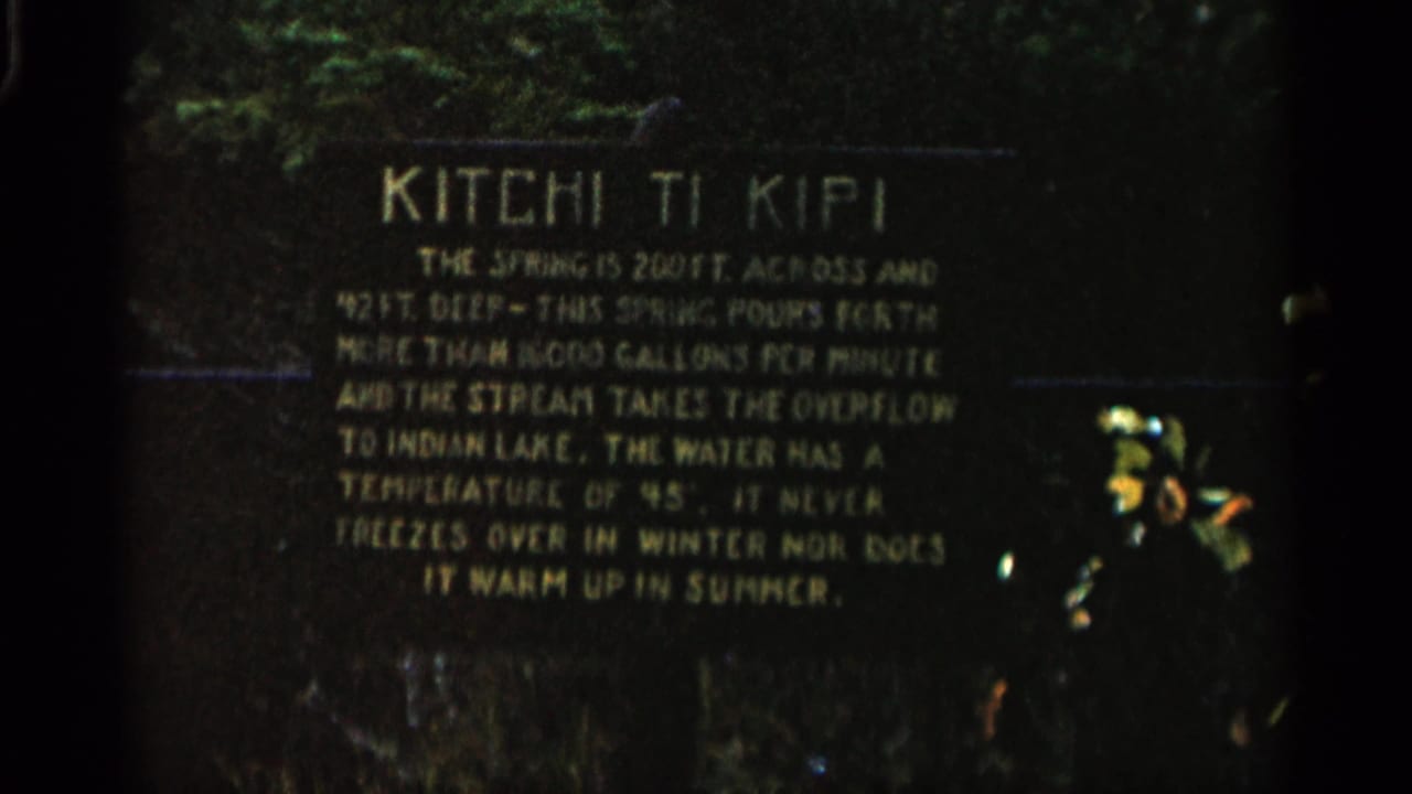 Kitchi Ti Kipi informational sign filmed in low light with text visible.