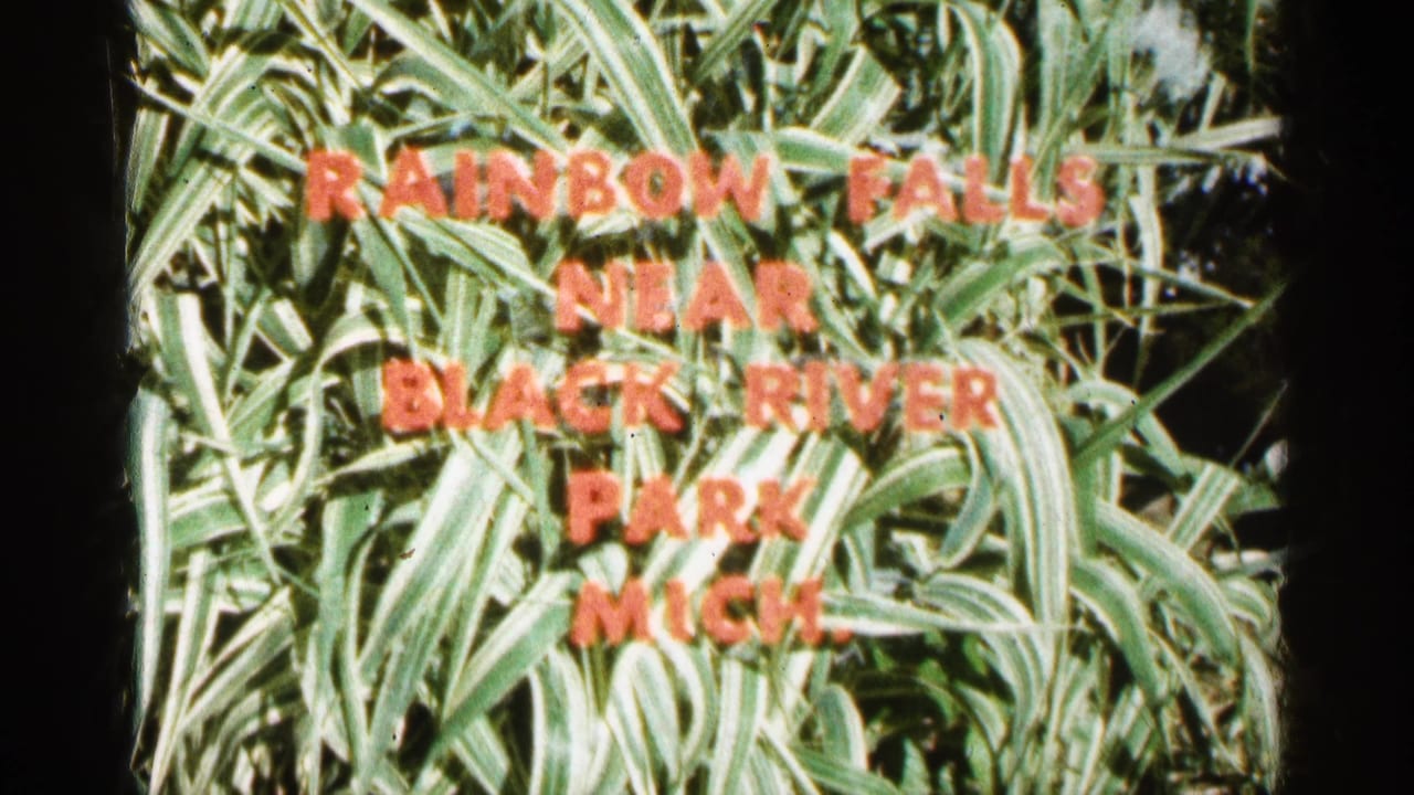 Red title lettering over green foliage naming Rainbow Falls near Black River Park, Michigan.