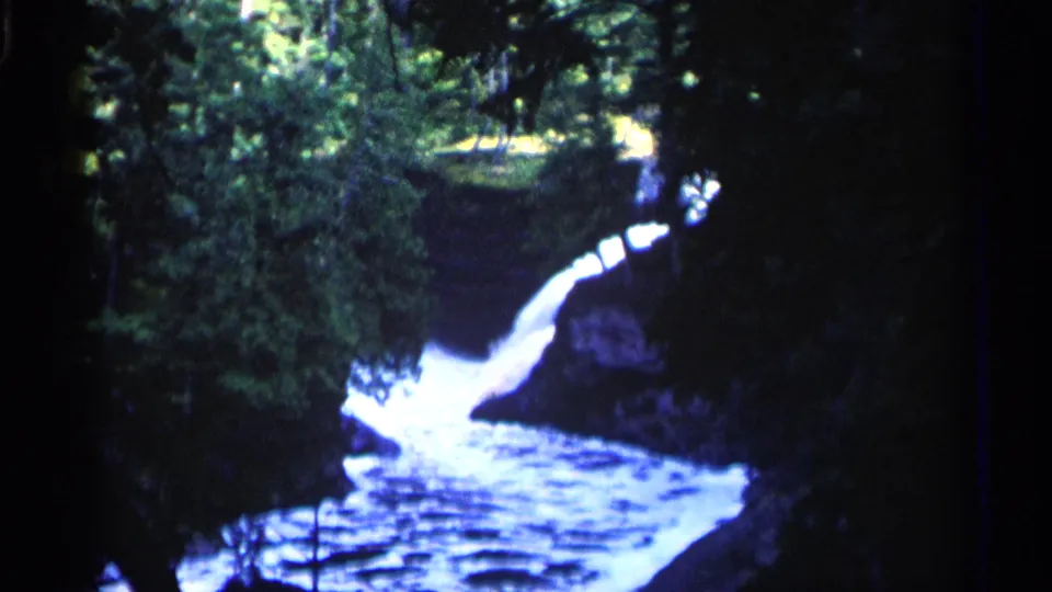 1960 Michigan 8mm frame of the waterfall and stream from a steady home-movie viewpoint.