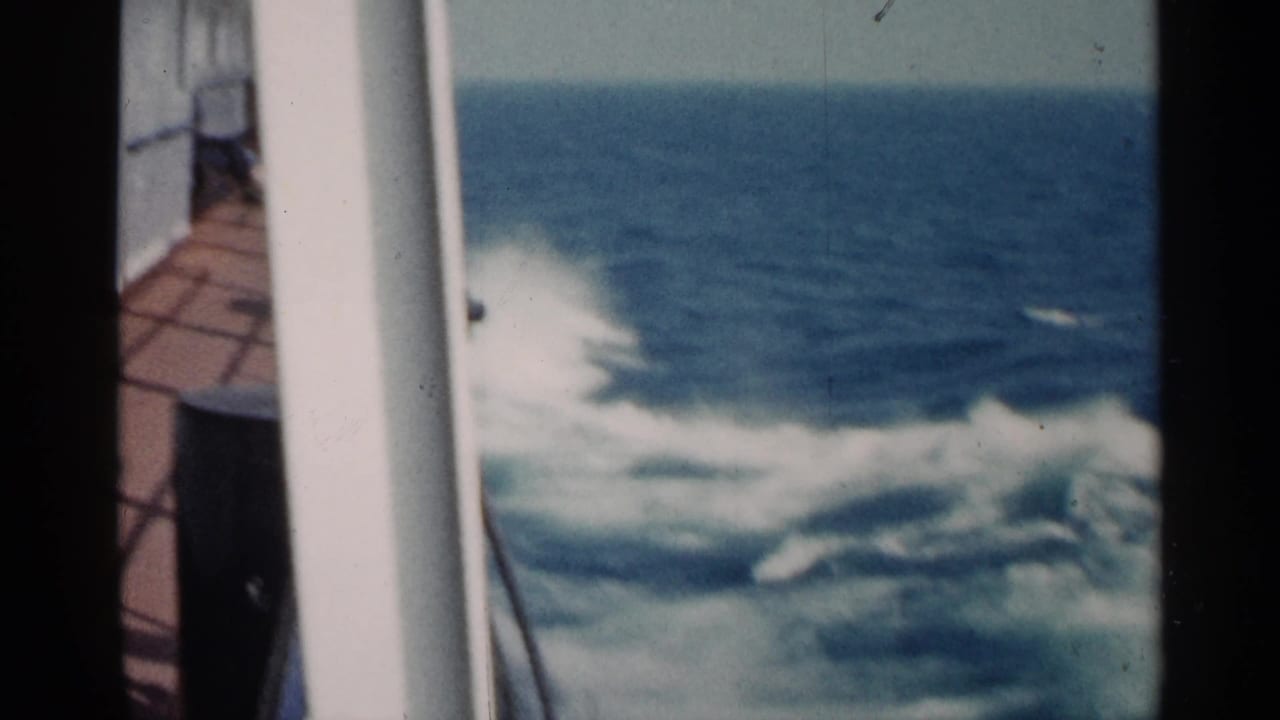 Early 1960s Michigan travel footage showing a white deck rail and churning water from a moving vessel.