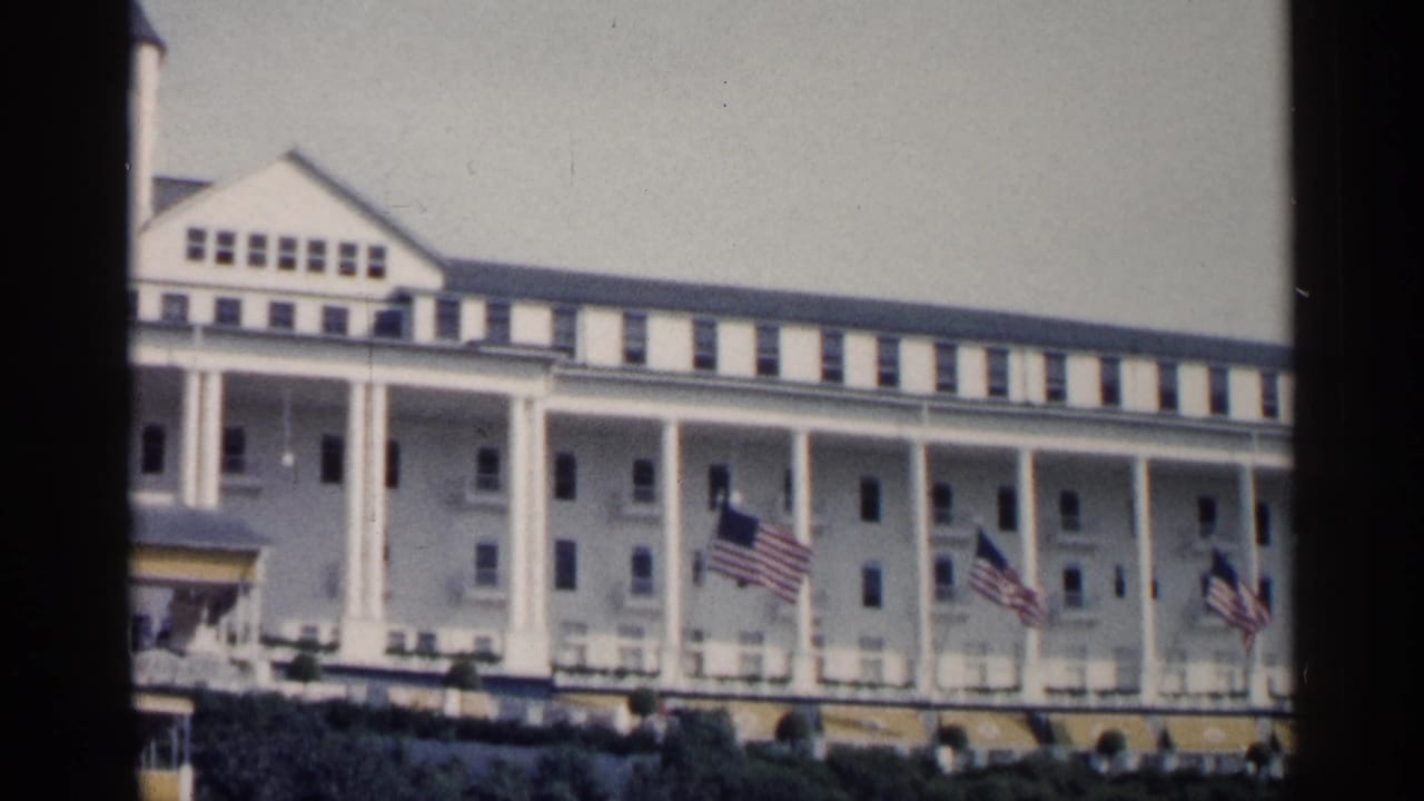 Long white hotel porch with several American flags flying.
