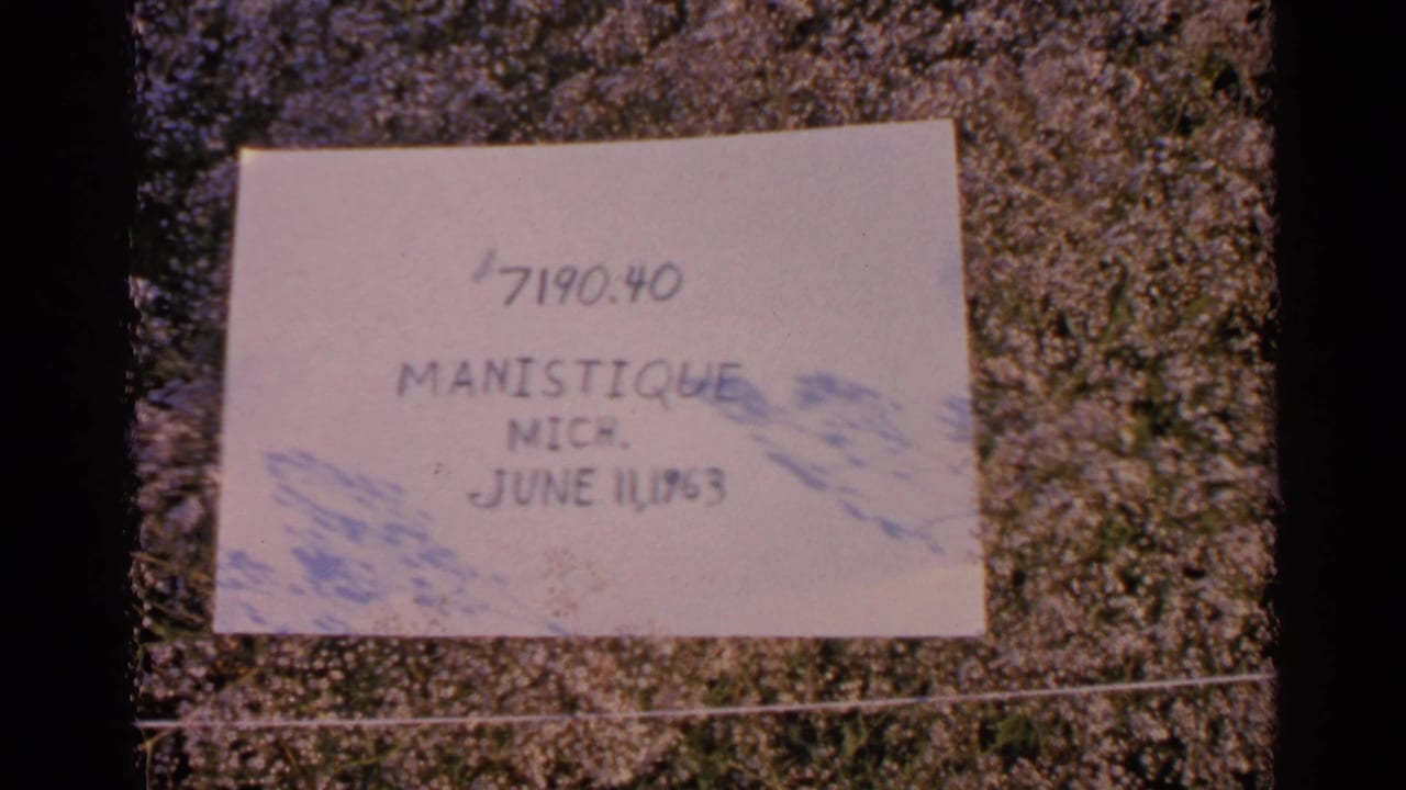 Handwritten leader card reading Manistique, Mich., June 1963, taped against a textured background.