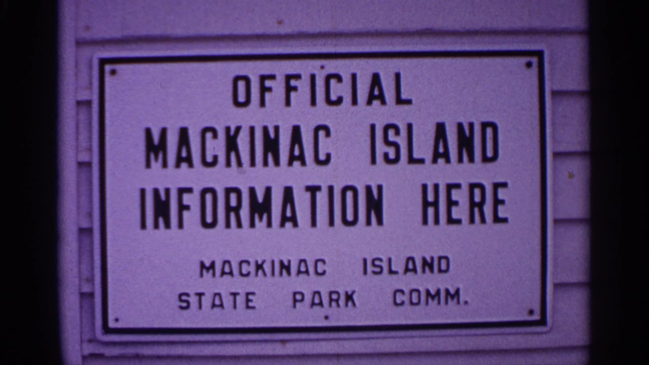 Close view of the same Mackinac Island information sign on siding.