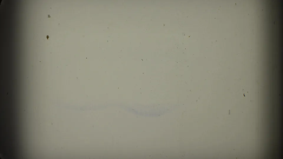 Faded 8mm frame from the 1961 Minnesota clip showing pale leader-like material, faint blue marks, dust, and dark frame edges.