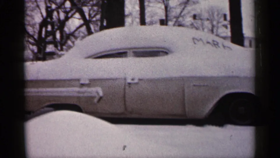 Final 1961 Minnesota frame of the snow-covered car, with MARK still visible and the rear wheel near the frame edge.