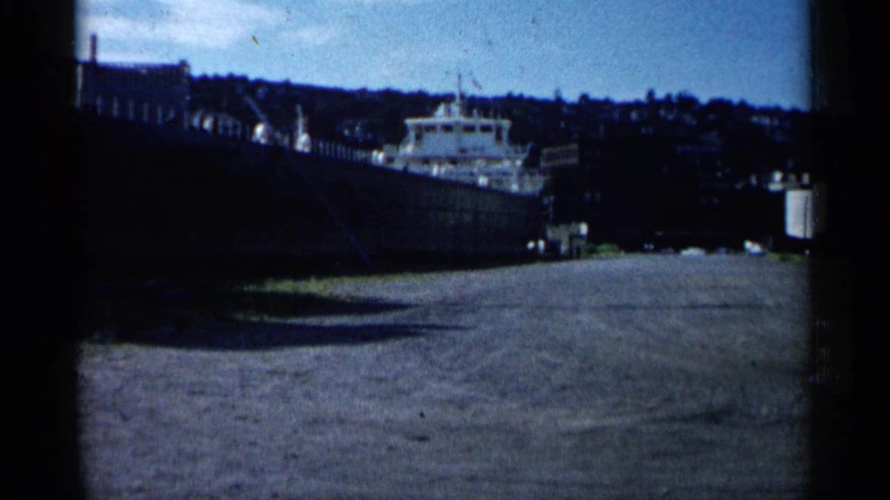 1961 Minnesota harbor view showing a large docked vessel beside pier structures, with shoreline and sky beyond.