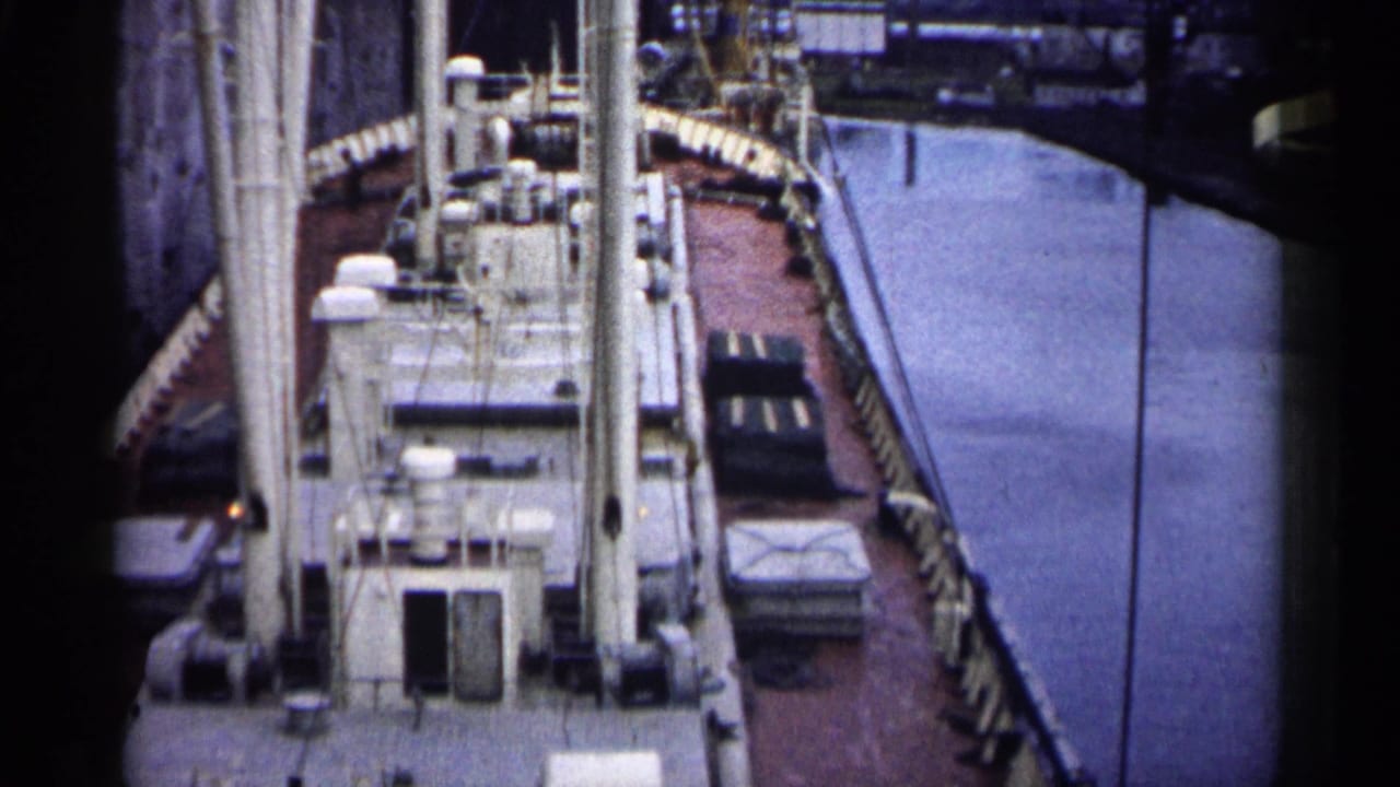 High-angle view down onto a ship deck beside a narrow waterway.