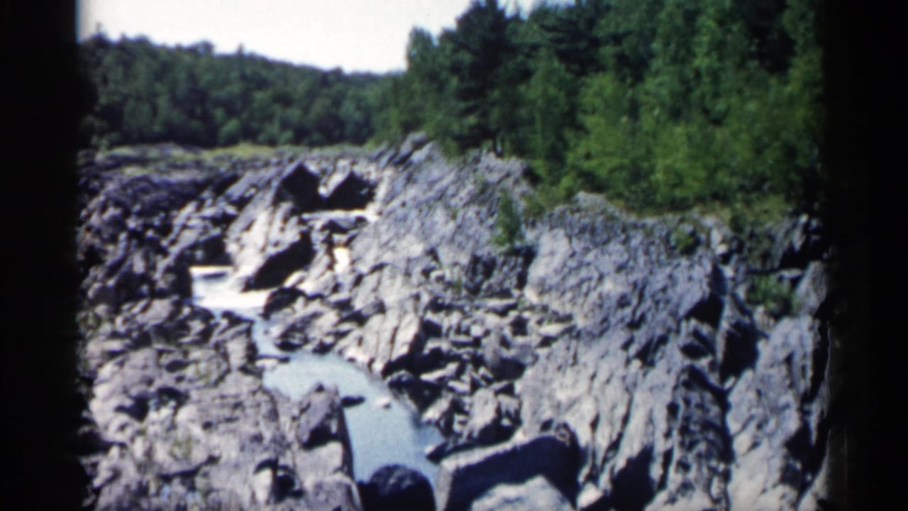 Rocky stream running through a wooded landscape with dark 8mm frame borders.