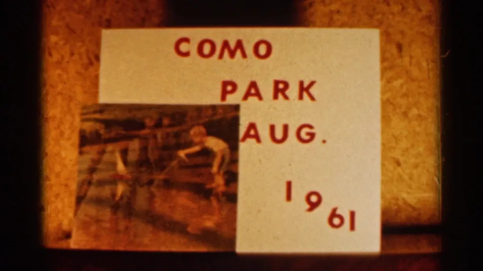 Hand-labeled 8mm title card for Como Park, August 1961, with red lettering and a small attached landscape photo.