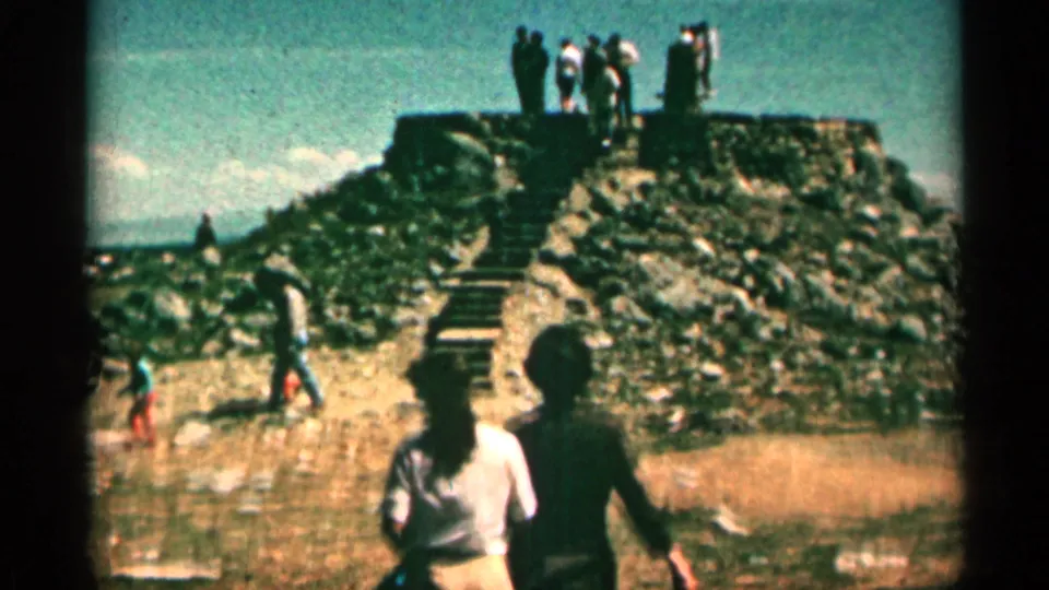 Visitors ascend and stand atop a stone pyramid lookout structure at Libby Flats Observation Point in Colorado.