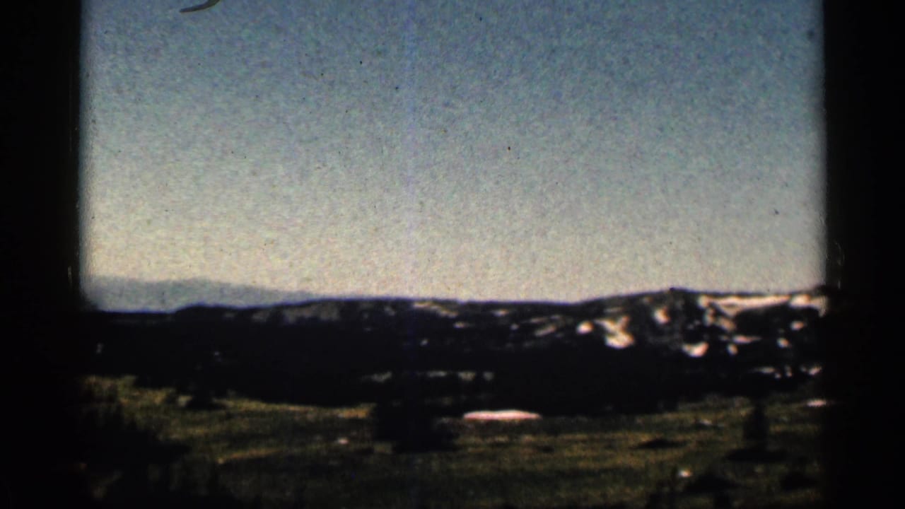 Distant ridgeline with patches of snow under a pale sky.