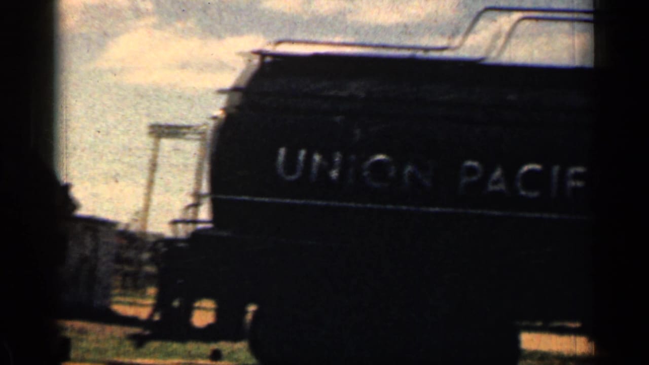 Dark Union Pacific rail car with lettering visible against the sky.