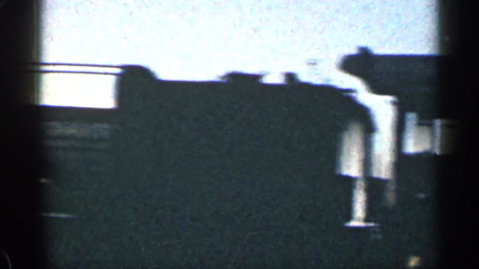 A close, soft 8mm view of train-side hardware and a dark rail-car edge during the Colorado journey.