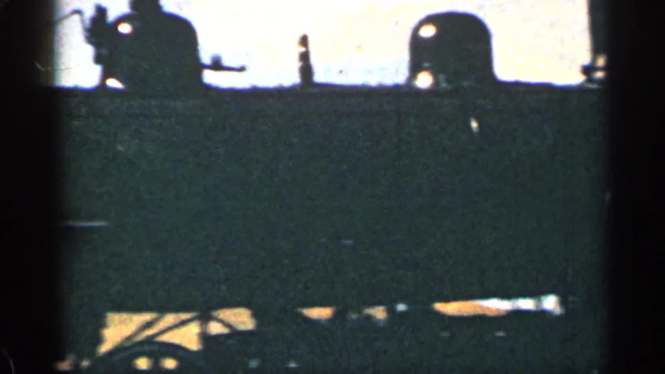 Silhouetted rail equipment and partial Union Pacific lettering close the short 1963 Colorado train sequence.