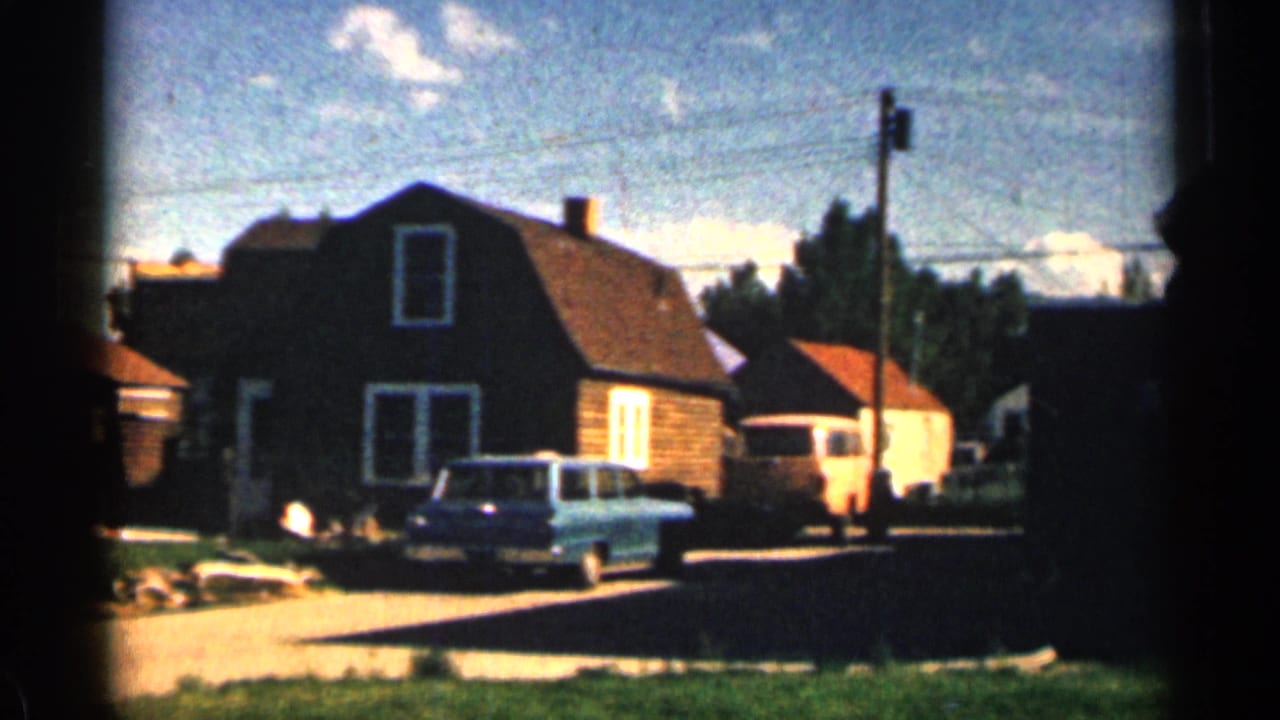 1963 Colorado street view with a house, a light blue station wagon, a nearby utility pole, and bright afternoon light.
