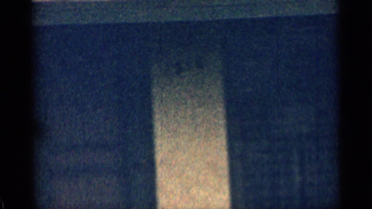 Blurred house exterior with a vertical light column or wall section.