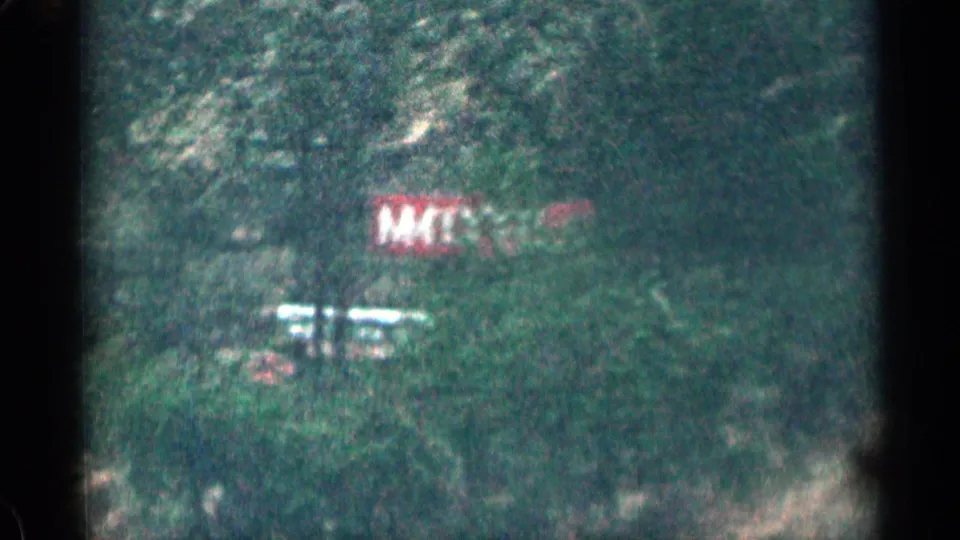 Soft 8mm frame of blurred roadside markings, vegetation and mountain terrain in Colorado.