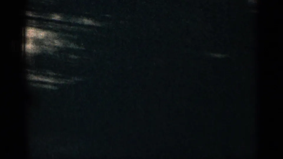 Dark 8mm Colorado travel frame with faint mountain or roadside forms and visible film texture.