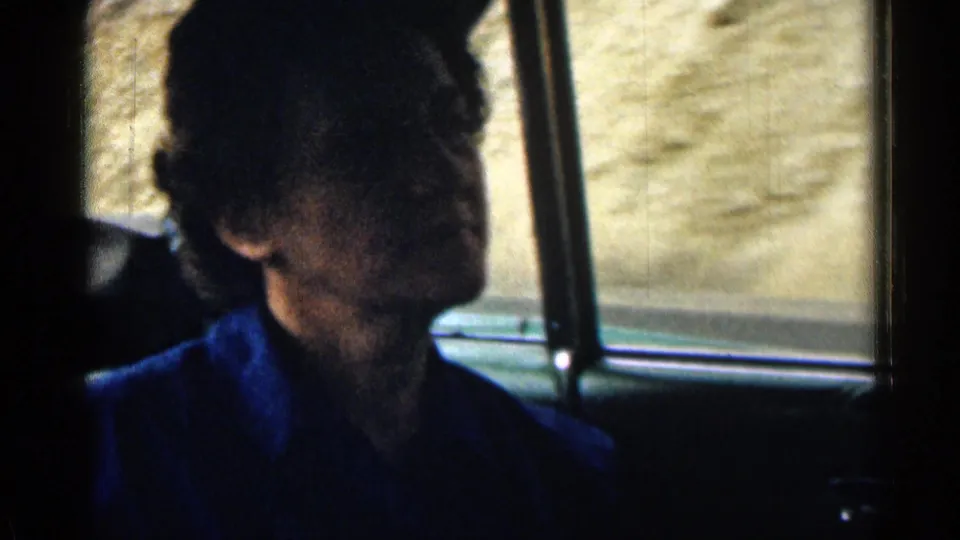 1963 Colorado road-trip frame showing a passenger in profile inside the car, partly shadowed by the window light.