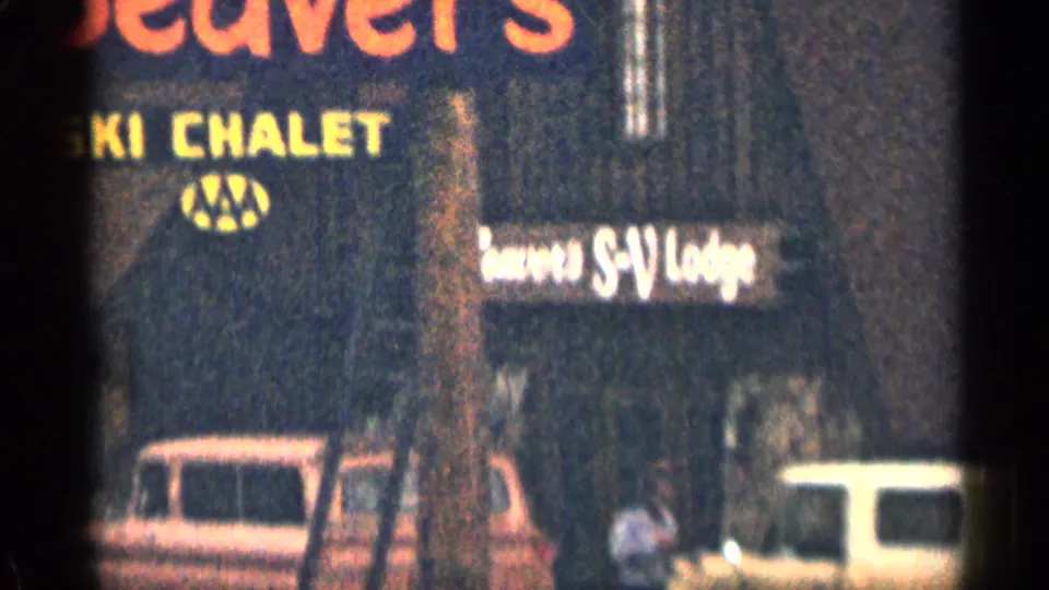 1963 Colorado 8mm frame of a passing roadside motel sign reading Beaver's Ski Chalet, with parked cars partly visible below.