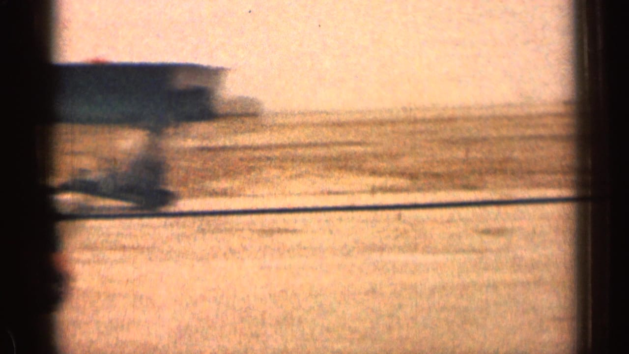 Blurred roadside or exterior view seen through dark framing.