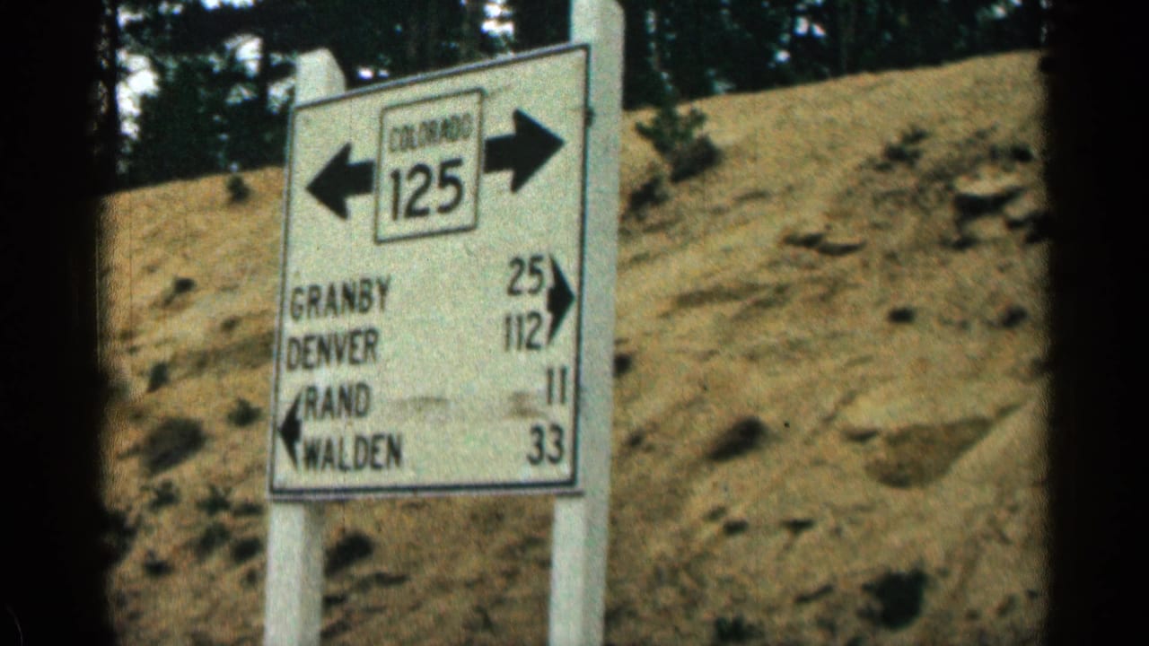 Closer view of a Colorado 125 sign with arrows and mileage on a rural roadside.