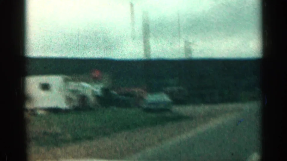 Faded 1963 Colorado road frame with a blurred parked vehicle or trailer shape, open horizon, and dark film-frame bars.
