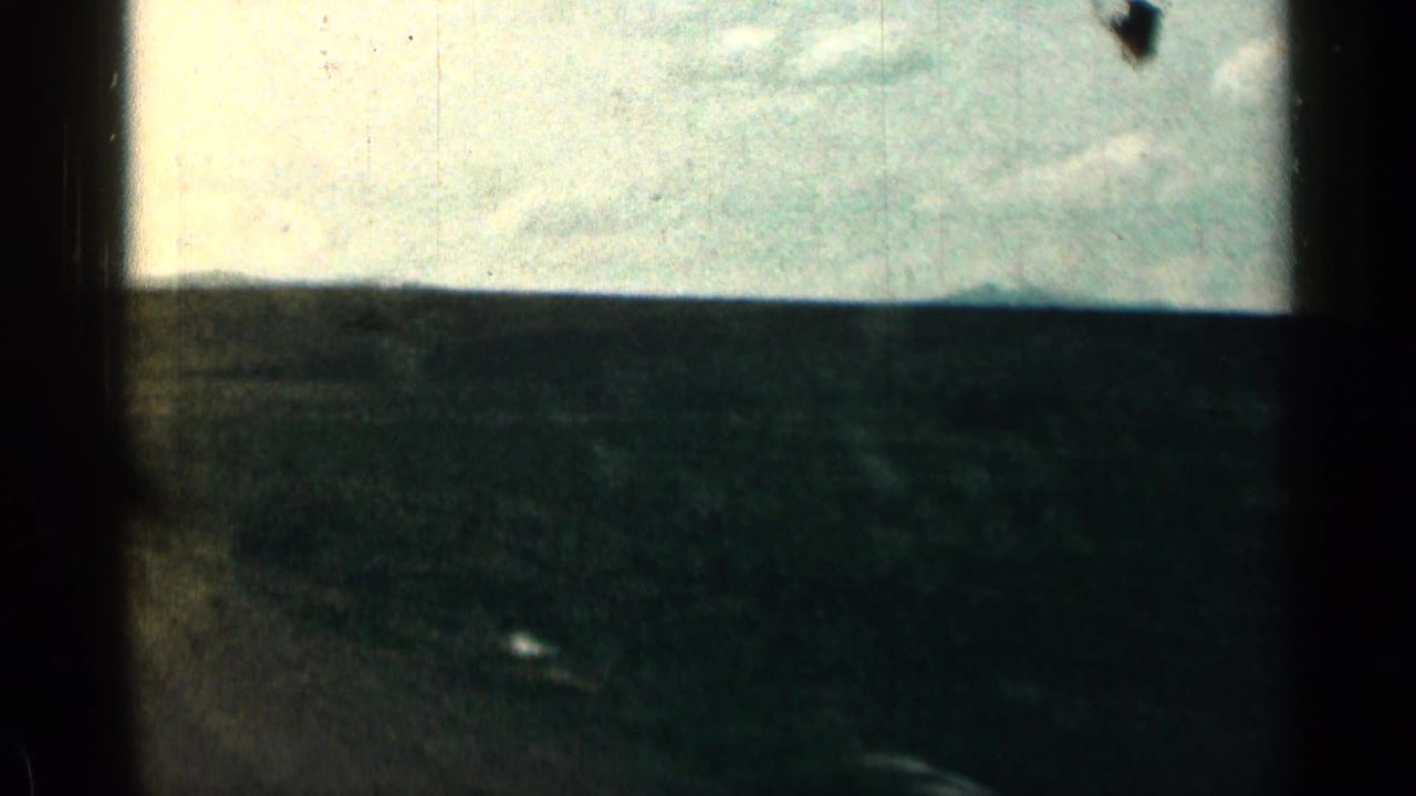 1963 Colorado 8mm frame showing open hills and sky through a dark vehicle-window edge.