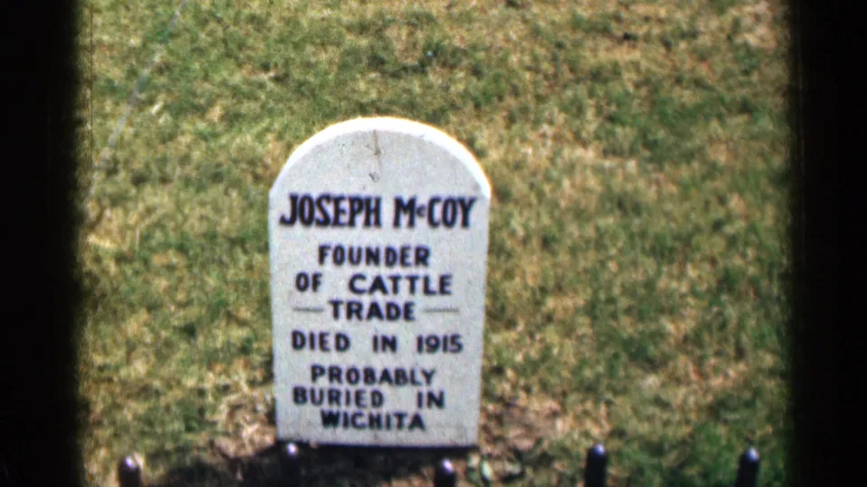 1963 8mm cemetery close-up of a white Joseph McCoy headstone reading founder of cattle trade and probably buried in Wichita.