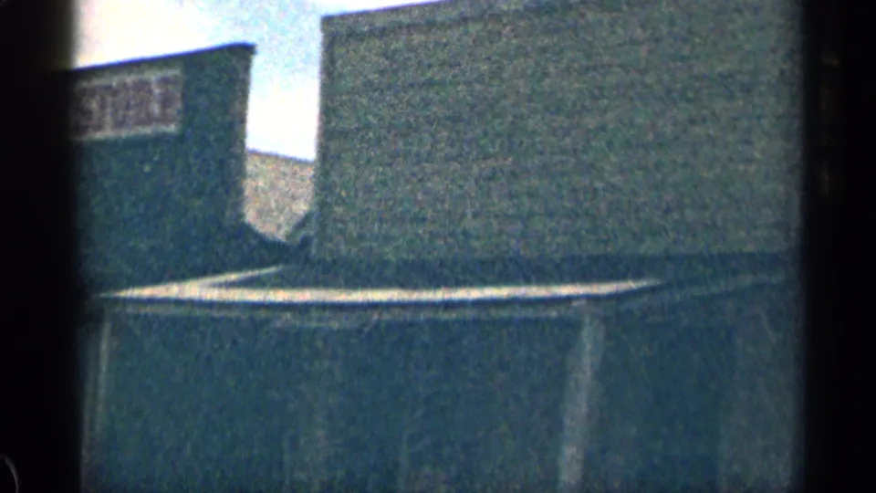 A backlit 1963 Colorado frame shows part of the “OLD COUNTRY STORE” sign next to a taller plain wall and roofline.