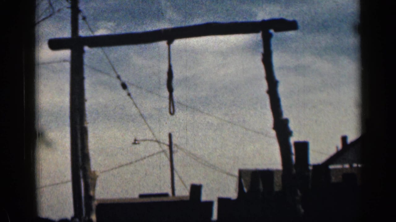 1963 Colorado 8mm frame showing a dark wooden frame or hoist-like structure silhouetted against clouds and utility lines.