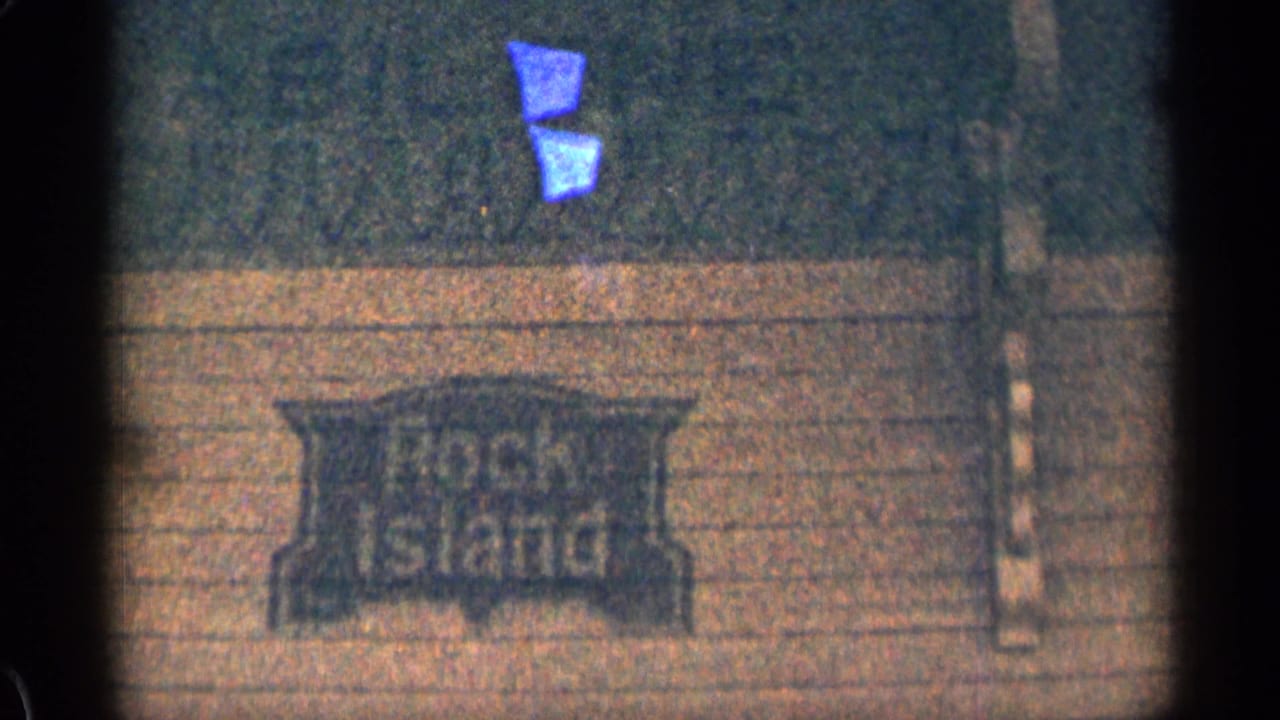 1963 Colorado 8mm frame showing a Rock Island sign on a building surface, with soft grain and dark frame edges.