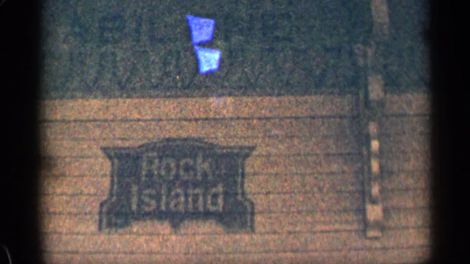 1963 Colorado 8mm frame showing a Rock Island sign on a building surface, with soft grain and dark frame edges.