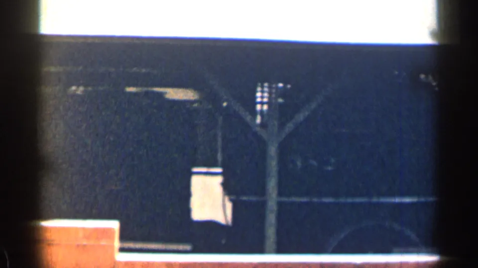 A stationary train car in the 1963 Texas footage appears behind a vertical obstruction, with a pale object hanging near the car side.