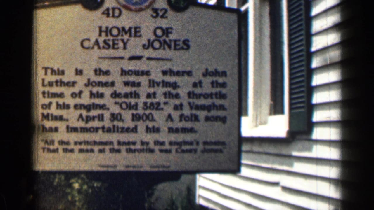 Historical marker reading Home of Casey Jones beside a clapboard building.