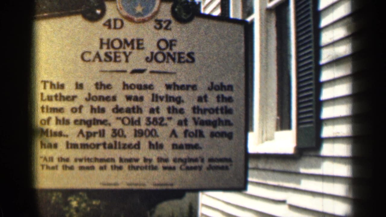 Home of Casey Jones marker fills the frame beside a dark shutter and white wall.