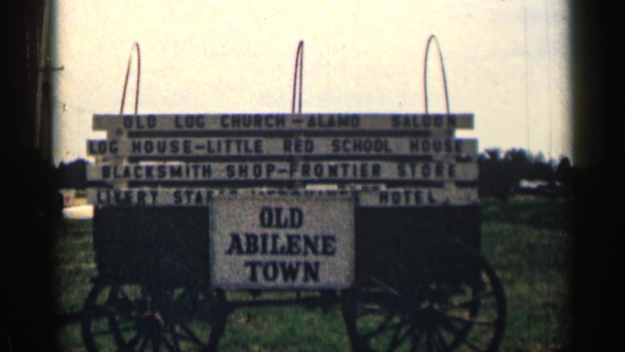 Wagon-mounted Old Abilene Town sign listing Western-themed attractions.