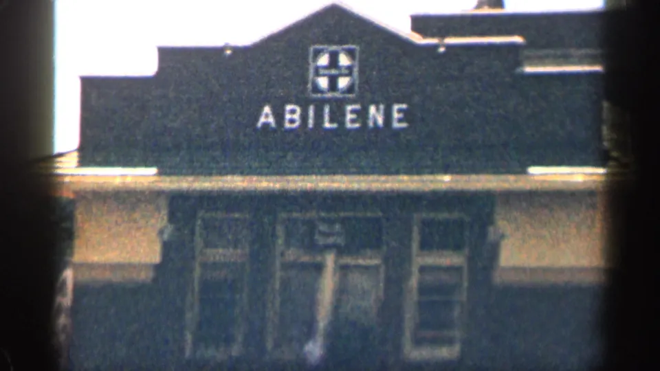 1963 Texas frame showing a dark commercial-looking building front with a clear Abilene sign and windows below.