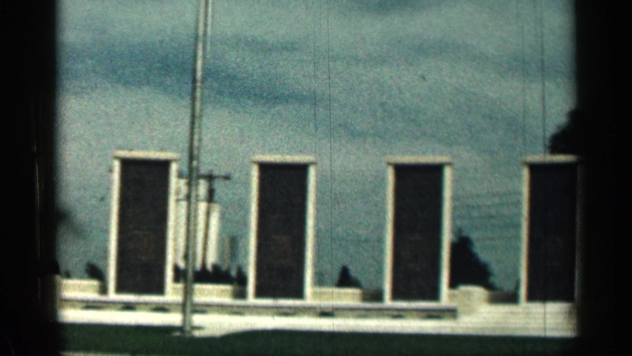 Memorial plaques and flagpole seen from a similar angle, with trees at the right edge.