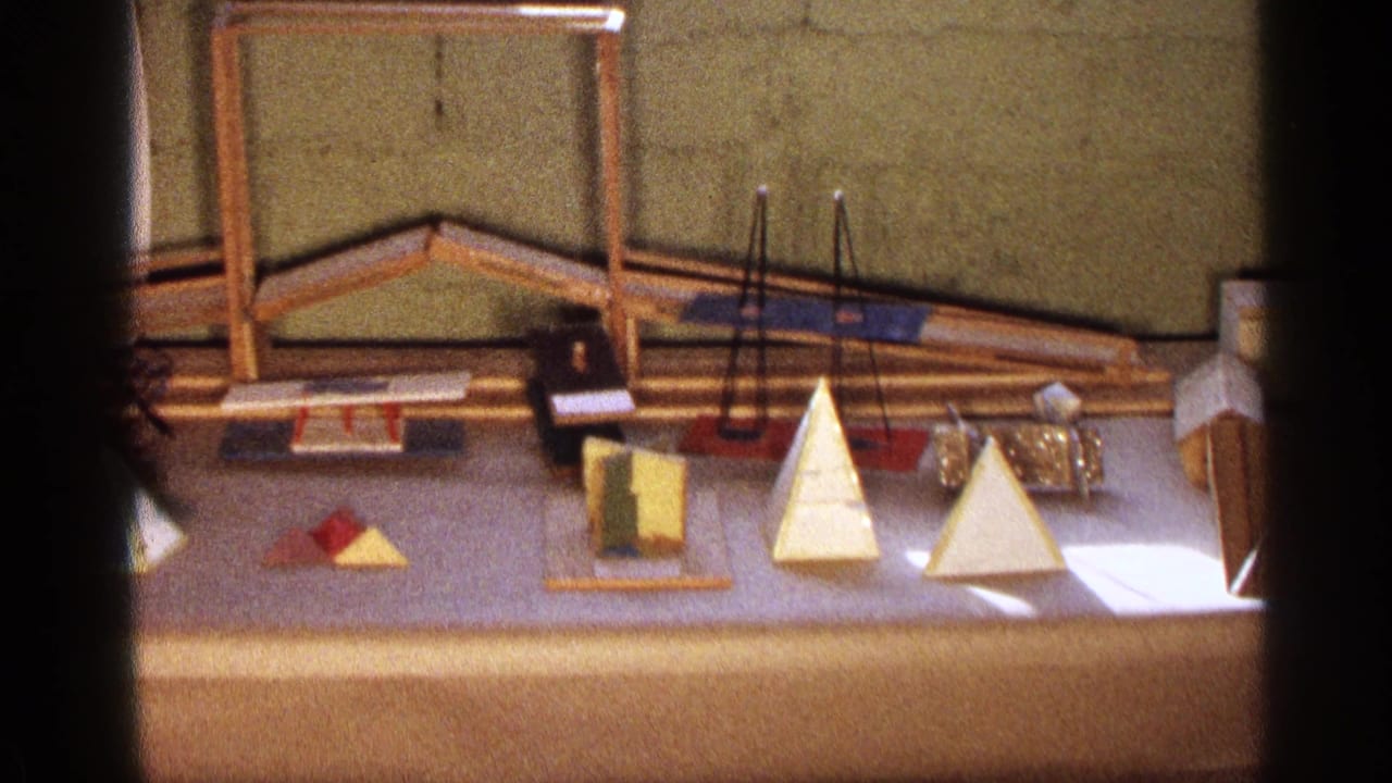 Geometric wooden forms and hanging rods displayed on a table.